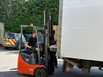 Forklift truck loading a pallet onto courier truck