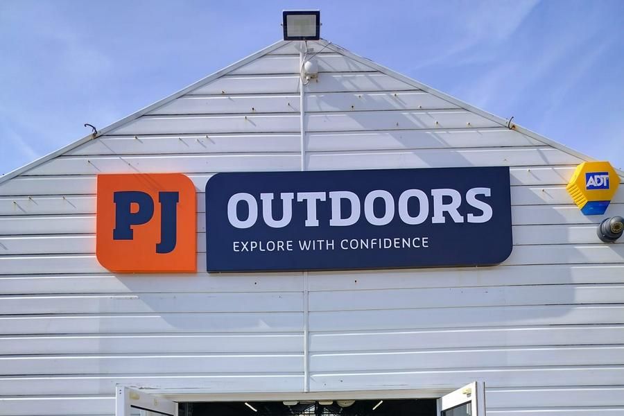 PJ Outdoors Tray Sign mounted to the front of a building